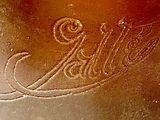a close up of a glass jar with a name etched on it