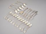 a group of silver spoons and forks arranged on a table