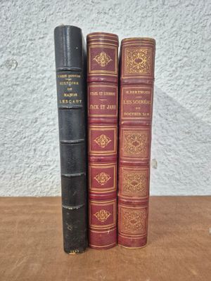 three old books sitting on top of a wooden table next to each other