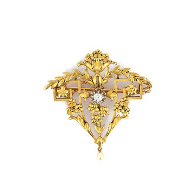 a close up of a gold brooch with a diamond in the center