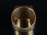 a close up of a gold ring on a black surface