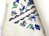 an old piece of cloth with blue and purple flowers on it