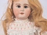 a doll that is wearing a white dress with red flowers on it