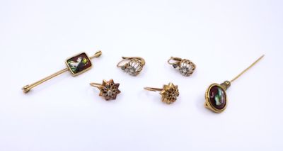 five pairs of earrings and a broocher on a white surface