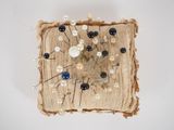 a piece of fabric with pins and pearls on it