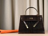brown alligator skin handbag on a wooden table with an orange umbrella