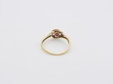 a close up of a gold ring with a ruby stone