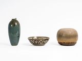 three vases and a bowl sitting next to each other on a white surface
