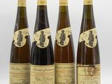 four bottles of wine are lined up on a white surface