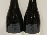 deux bouteilles de vin posées sur une table l'une à côté de l'autre
