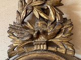 a gold clock with a bird on top of it