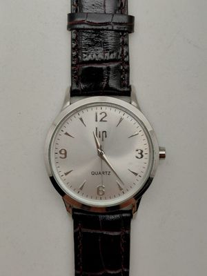 une montre posée sur une surface blanche