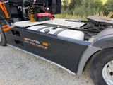 a semi truck with a flat bed parked on the side of the road