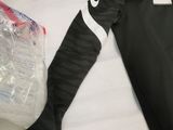 a black and white shirt and a bag of water on a bed