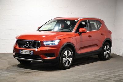 a red volvo suv parked in a garage with a checkered floor