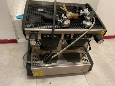 une photo d'une machine à café posée sur un sol carrelé