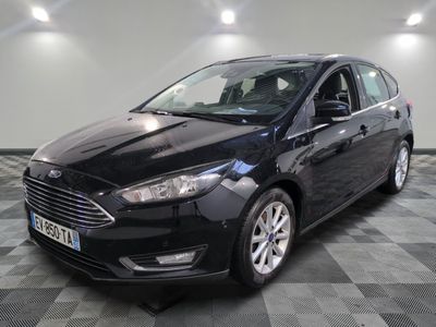 La Ford Focus noire est garée sur un sol carrelé à damier.