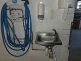 une photo d'une salle de bains avec un lavabo et des tuyaux fixés au mur