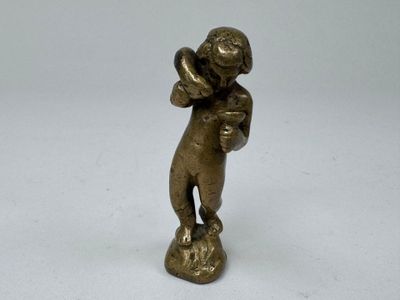 une vieille figurine en bronze représentant un homme tenant une batte de baseball
