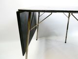 une petite table à plateau rabattable sur fond blanc