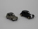 two toy cars sitting next to each other on a white surface