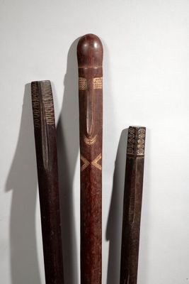 three baseball bats that are standing up against a wall