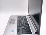 a silver laptop with a black keyboard on a white surface