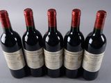 six bottles of wine are lined up in a row on a table