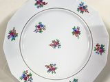 a white plate with colorful flowers on it on a table