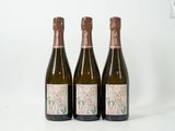 trois bouteilles de vin posées les unes à côté des autres sur une surface blanche