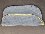 a small grey bag with yellow zipper sitting on top of a table
