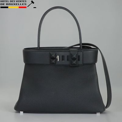 un sac à main en cuir noir orné d'un nœud sur la poignée