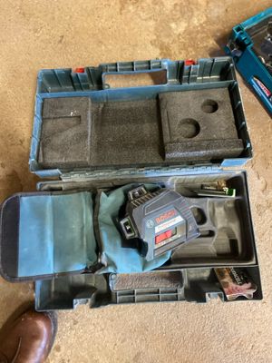 a tool in a case on the floor next to a pair of shoes
