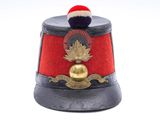 un chapeau rouge orné d'une clochette dorée