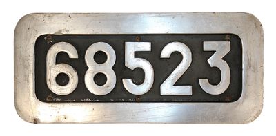 une plaque métallique sur laquelle figure un numéro, sur fond blanc