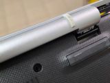 a close up of a laptop with a pen sticking out of it ' s side