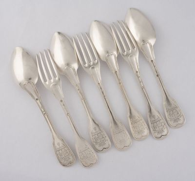 six cuillères en argent et une fourchette posées sur un plateau blanc