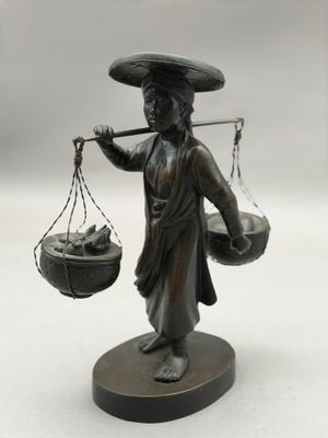 statue en bronze représentant une femme portant un panier de provisions sur la tête
