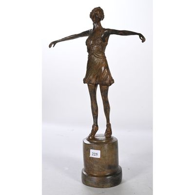 une statue en bronze représentant une femme tenant une raquette de tennis
