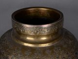 a gold vase with a black lid sitting on a table