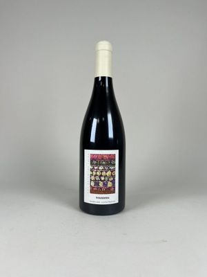 une bouteille de vin rouge posée sur une table blanche