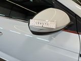 a white car with a sticker on it ' s side mirror