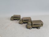three toy army vehicles that are sitting on a table