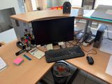 a desk with a computer, keyboard, mouse, and other items on it