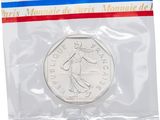 a close up of a coin in a plastic bag on a white background