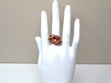 a white mannequin hand holding a ring with a donut on it