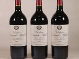 trois bouteilles de vin rouge posées sur une table blanche