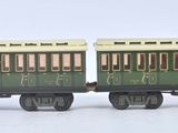 deux petits trains miniatures posés côte à côte sur une surface blanche