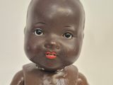 a brown baby doll with a red lip on it ' s face