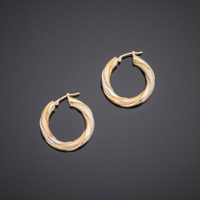 a pair of gold hoop earrings on a black background